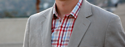 A man wearing a suit and checked shirt