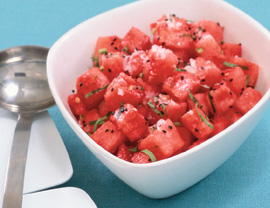A bowl of food on a plate, with watermelon