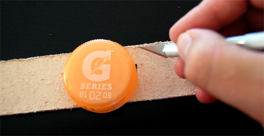 Use a Gatorade cap as a template for cutting the end of the belt