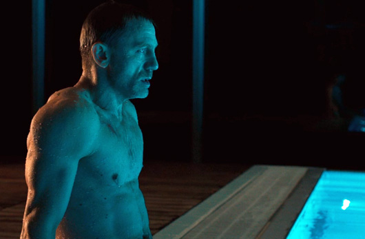 Daniel Craig sitting next to pool