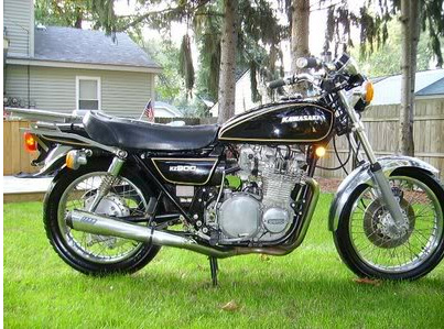 A KZ900 motorcycle parked in front of a house