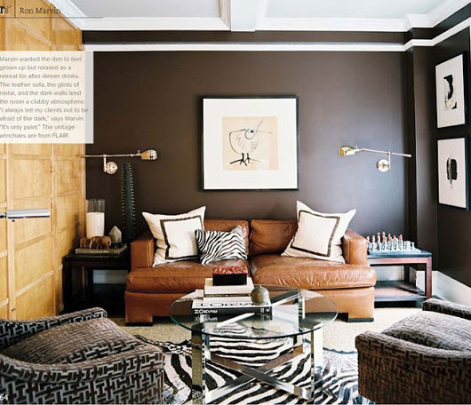 A living room with a couch and a brown wall