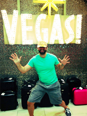 Man standing in front of Vegas sign