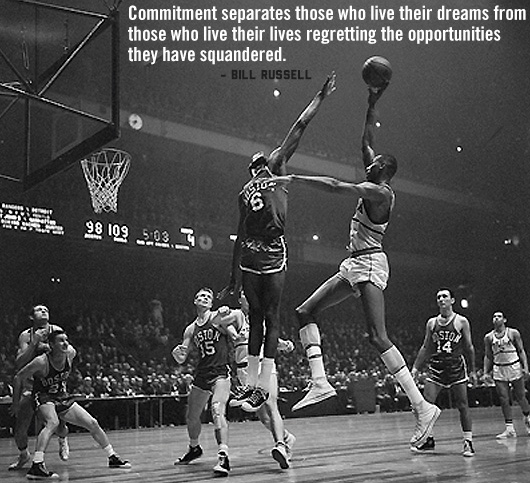 A group of people playing on a basketball court with a Bill Russell quote
