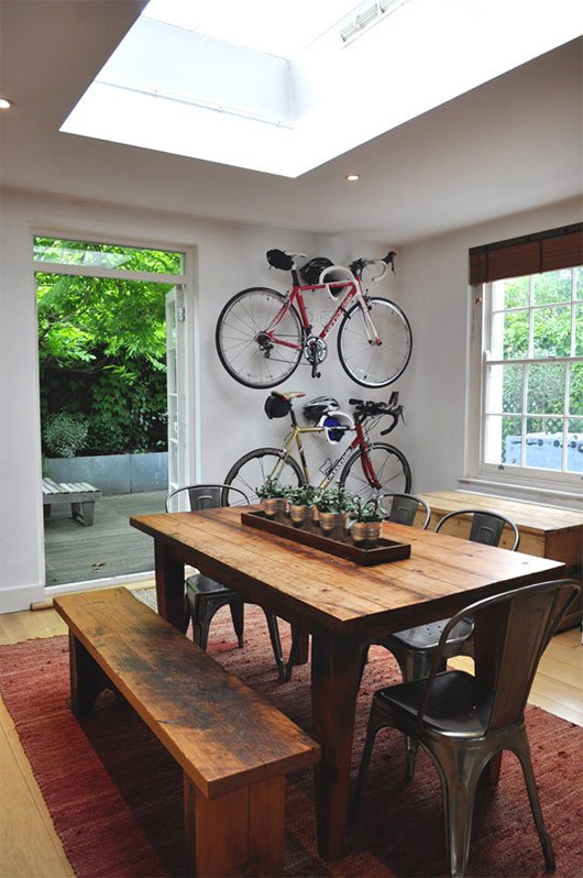 A dining room table in front of a window with bicycles