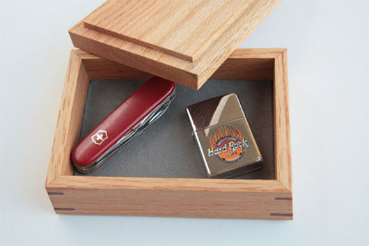 A wooden box with knife and lighter
