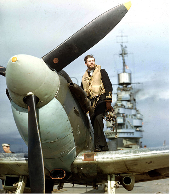 A man standing next to a plane, with Supermarine Seafire