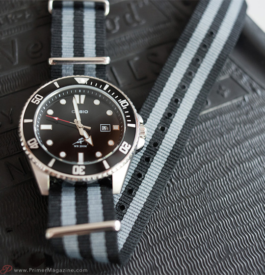 A close up of a watch on a striped strap