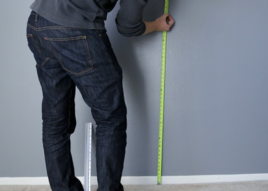 Using a tape measure to mark wall