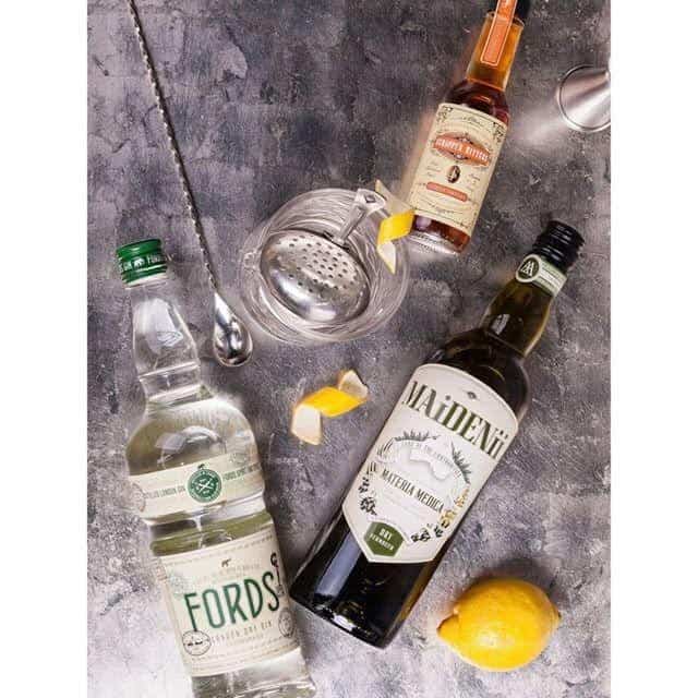 The ingredients of a traditional martini: Gin, vermouth, and orange bitters with lemon peel