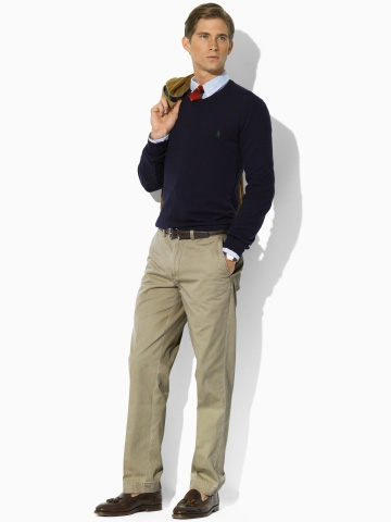 a man wearing well fitting chino pants with a sweater over a shirt and tie