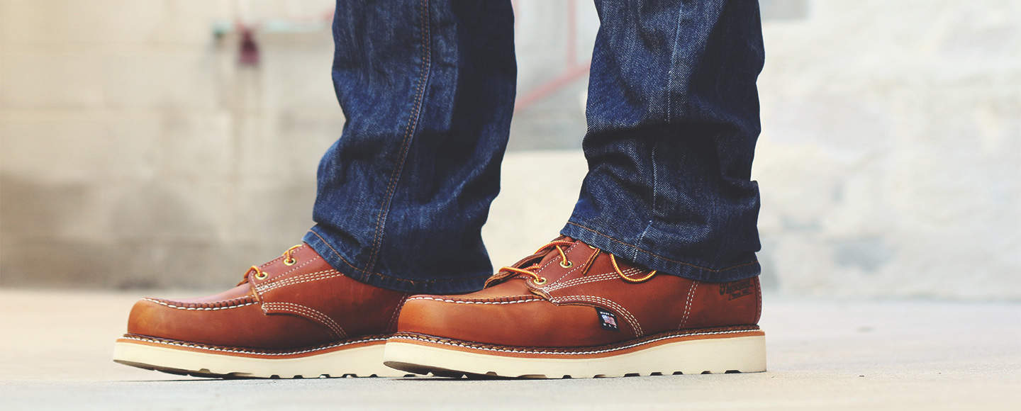 close up details of a person wearing a pair of thorogood moc toe boots