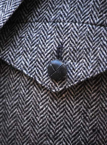 pocket and button detail of herringbone sportcoat