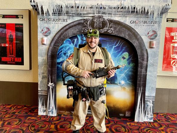 a man wearing a screen accurate ghostbusters costume