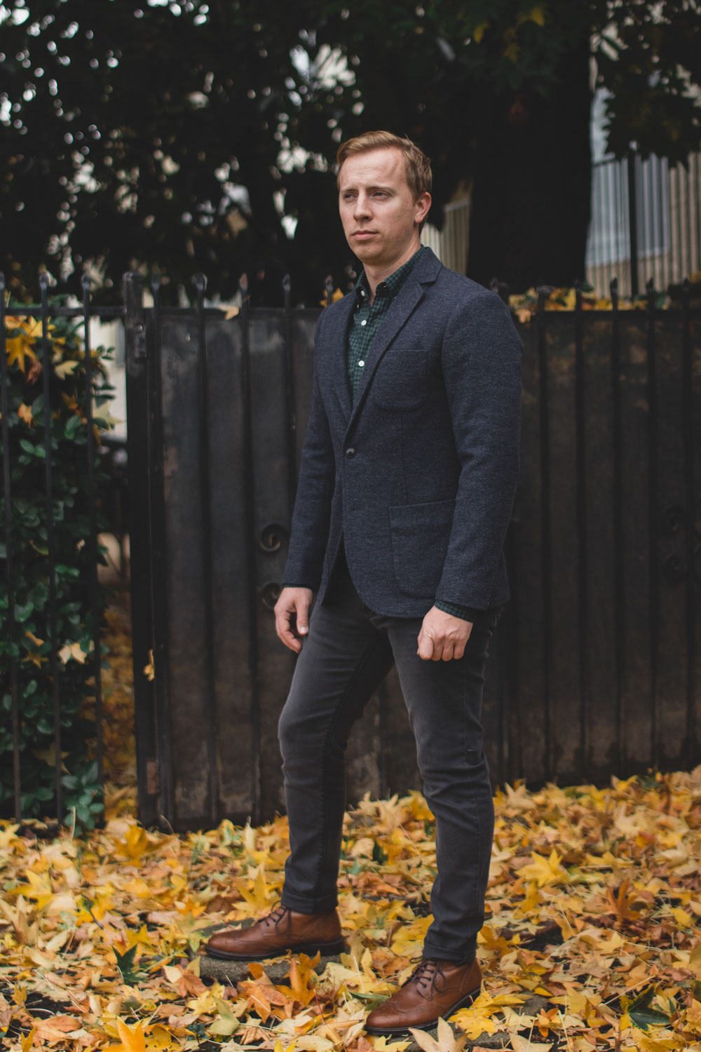 men's outfit featuring navy blazer, green check shirt, grey jeans