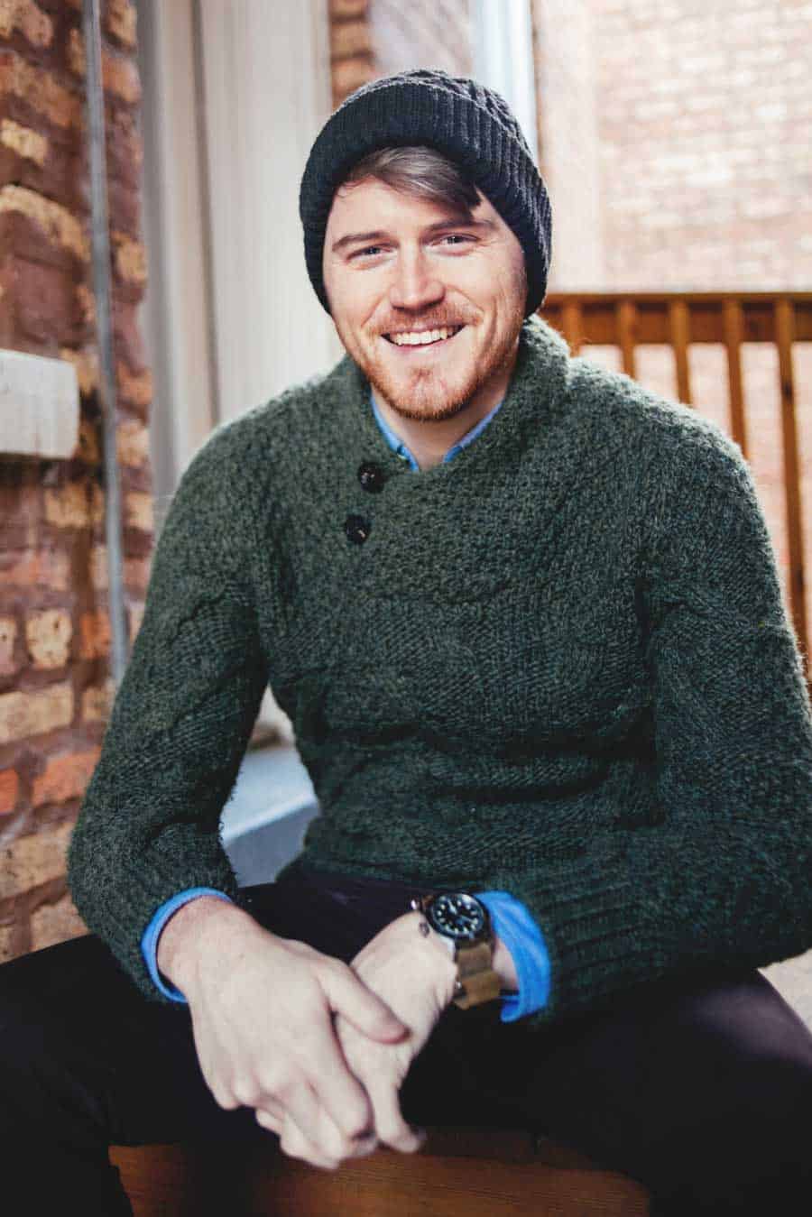man smiling wearing aran sweater