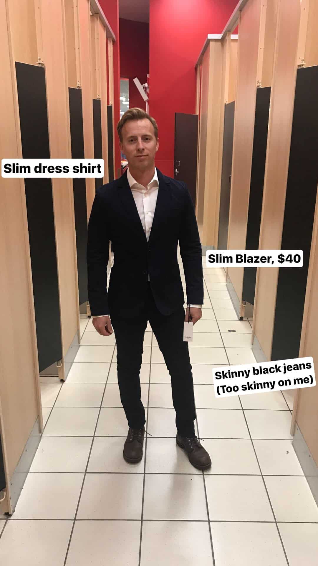 Man in fitting room wearing dress shirt, blazer and skinny jeans