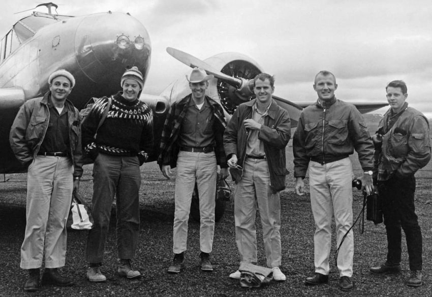 several men standing in front of aircraft