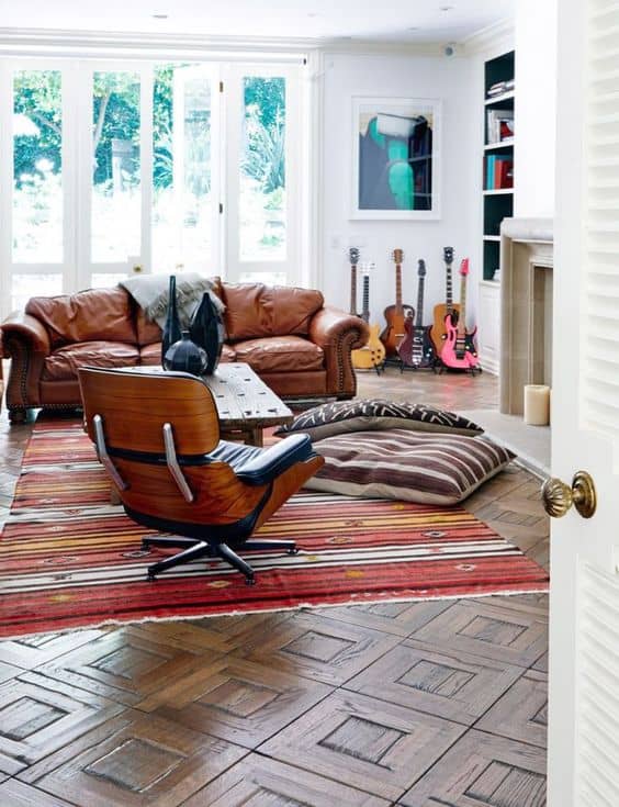 A living room filled with furniture and a large window with lots of guitars