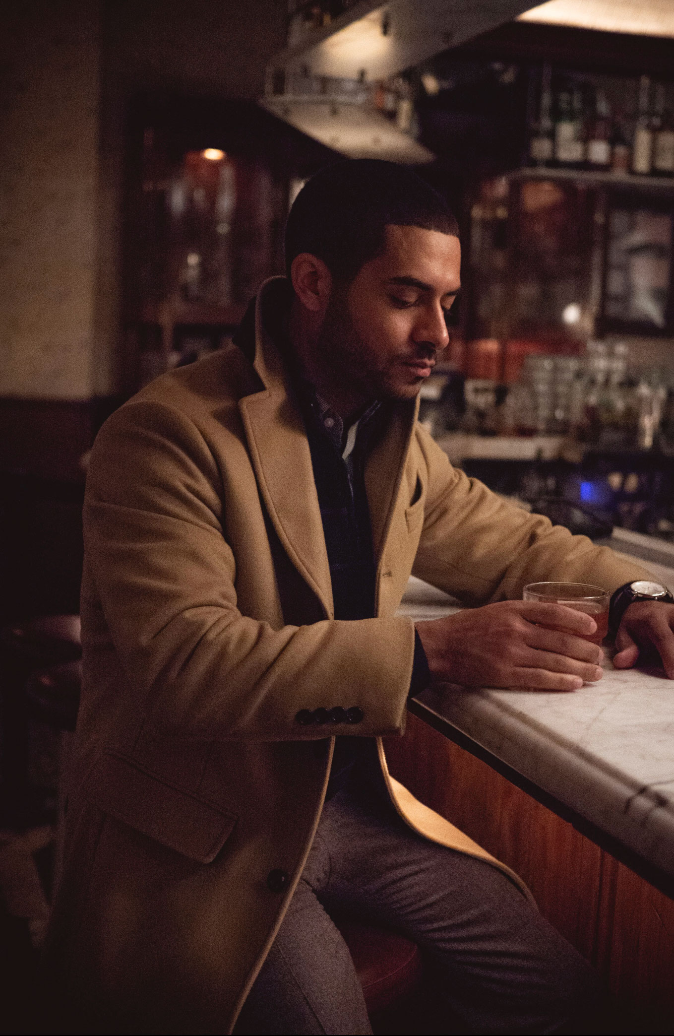 A man drinking a cocktail in a bar