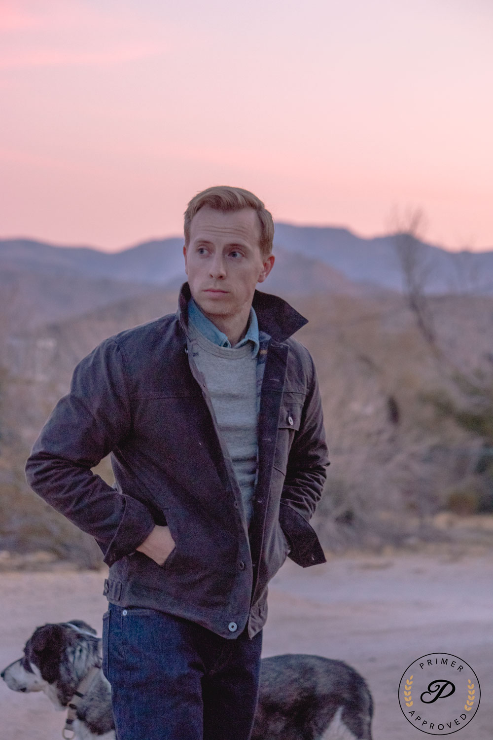 a man wearing a Flint and Tinder waxed canvas jacket over a sweater and collared shirt