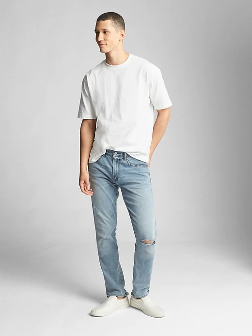 A person standing posing for the camera wearing gap jeans