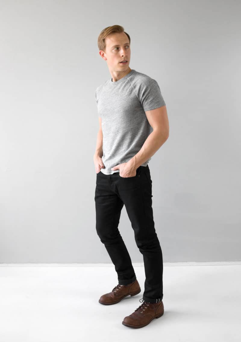 a minimalist outfit with gray t-shirt, black jeans, and brown boots