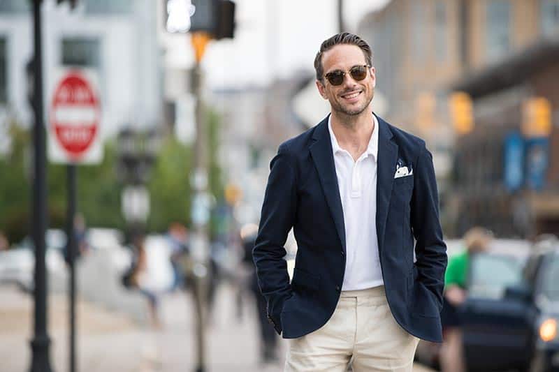 a man wearing a navy blazer over a polo shirt