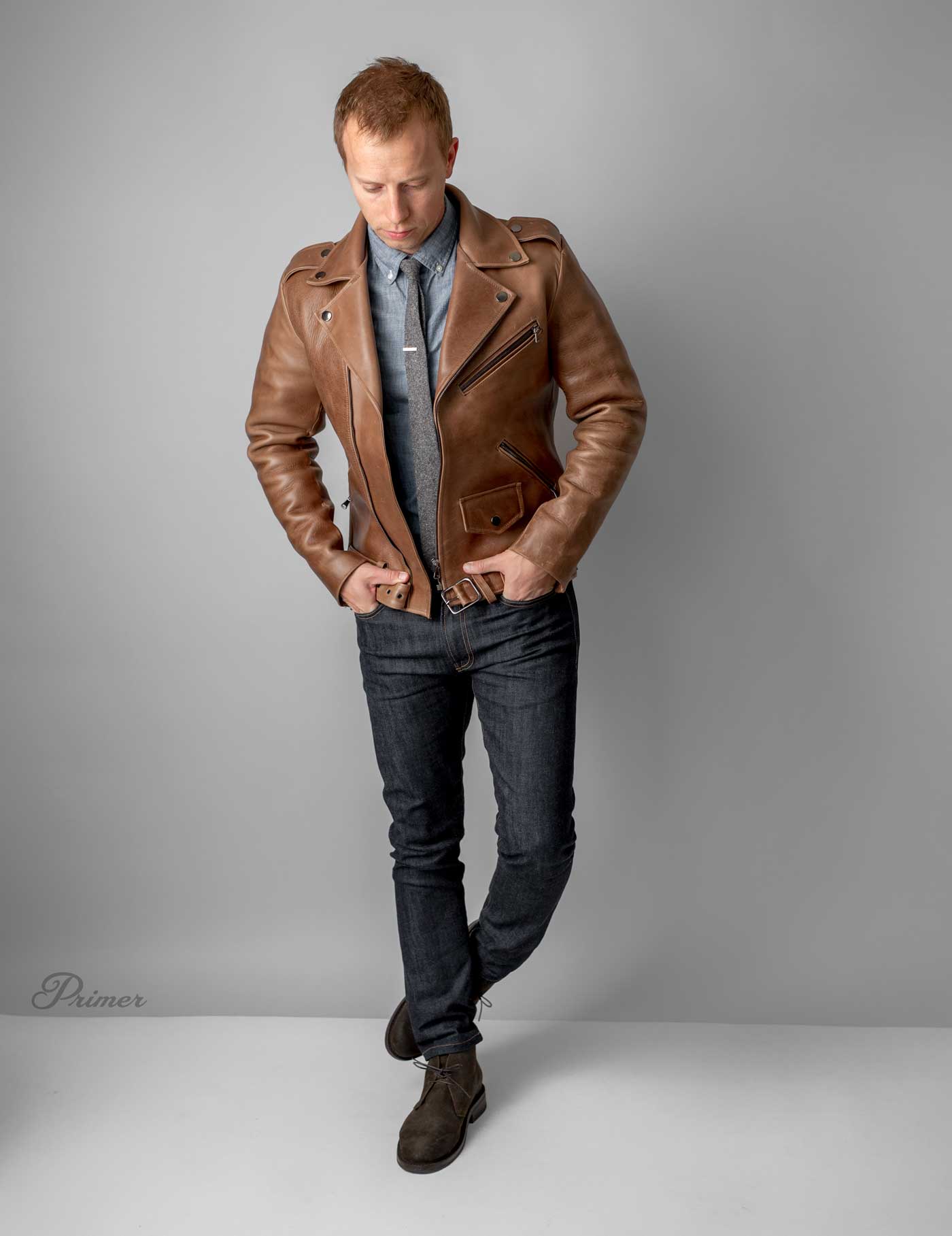 brown leather motorcyle jacket with jeans and tie