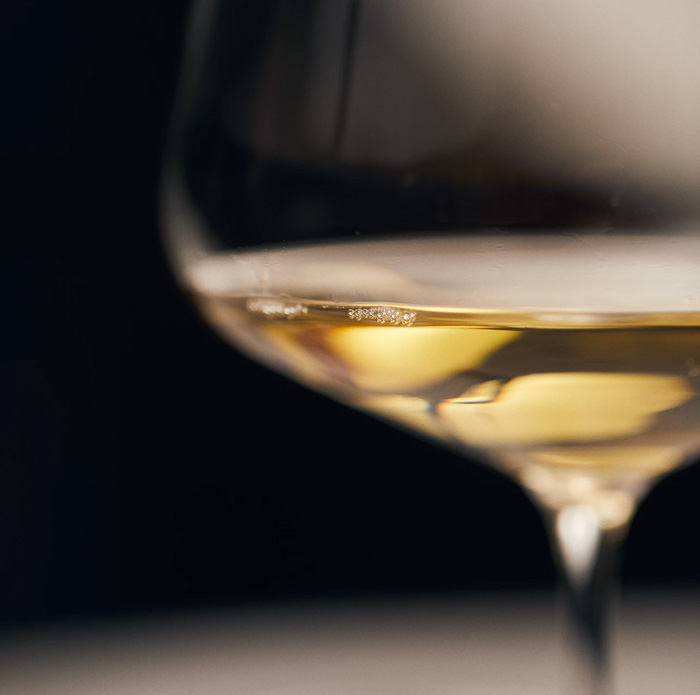 a close up image of white wine in a wine glass