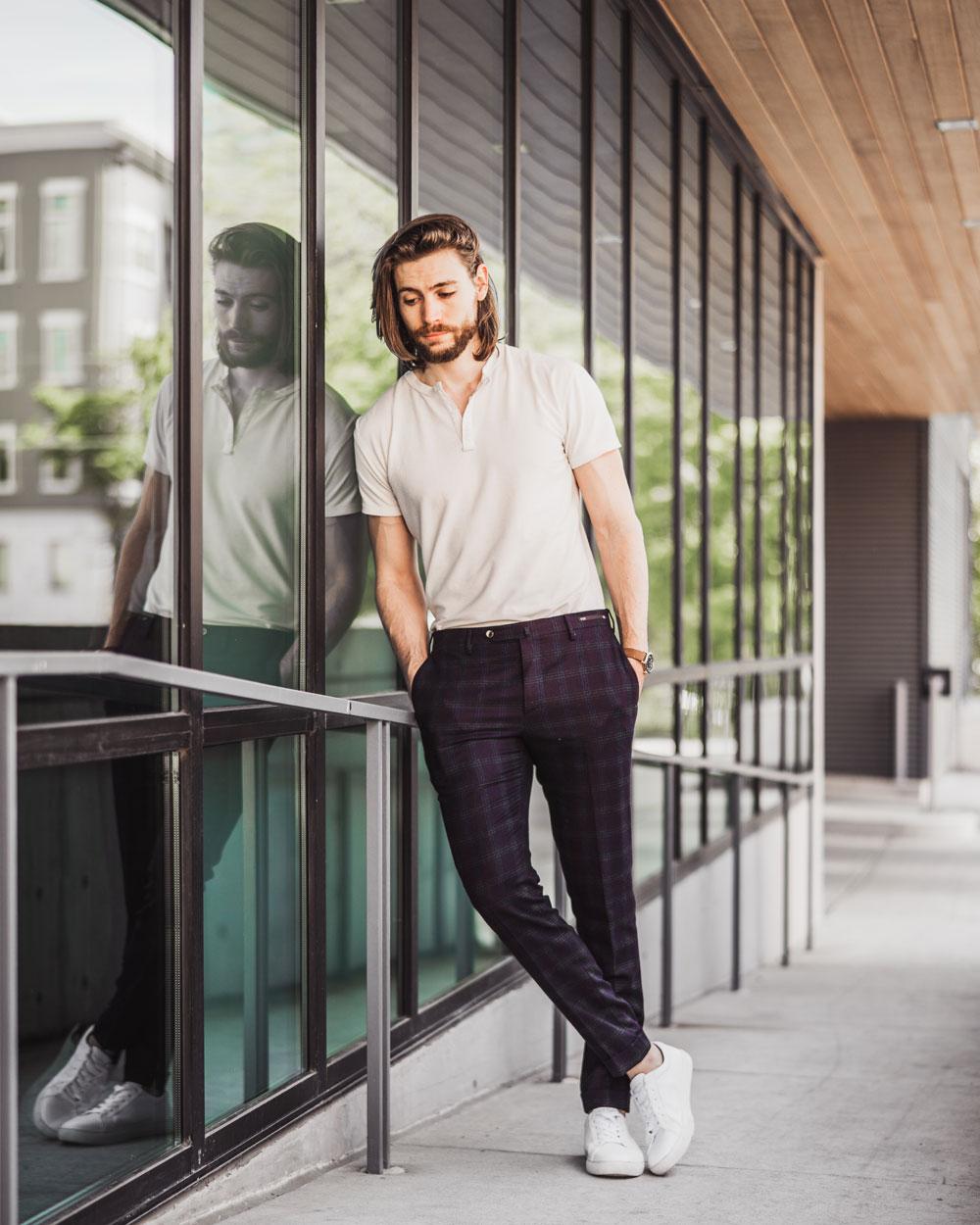 A man standing in front of a window posing for the camera, with Dress Pants