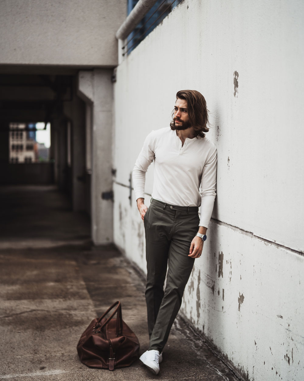 man wearing white henley with green dress pants and white sneakers