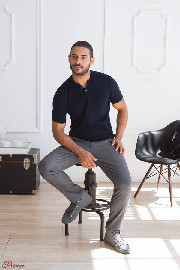 a man wearing a smart casual first date outfit example of a polo shirt, slim fit pants, and high top sneakers