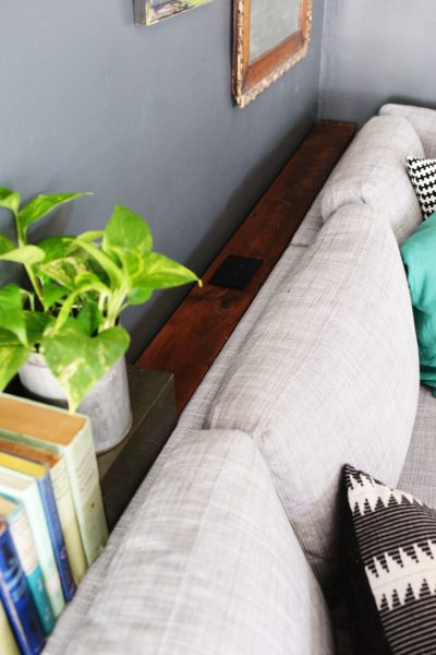 a space saving narrow table behind a sofa for storage 