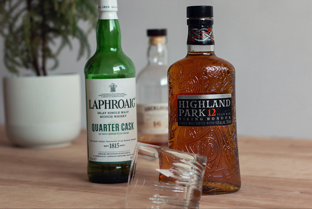 three bottles of liquor and a cocktail glass on a table