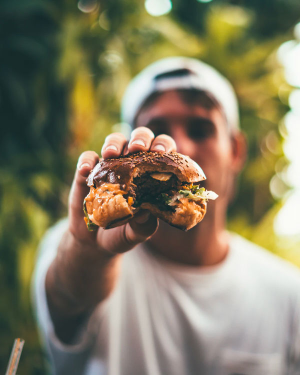 a man holding a half eaten burger