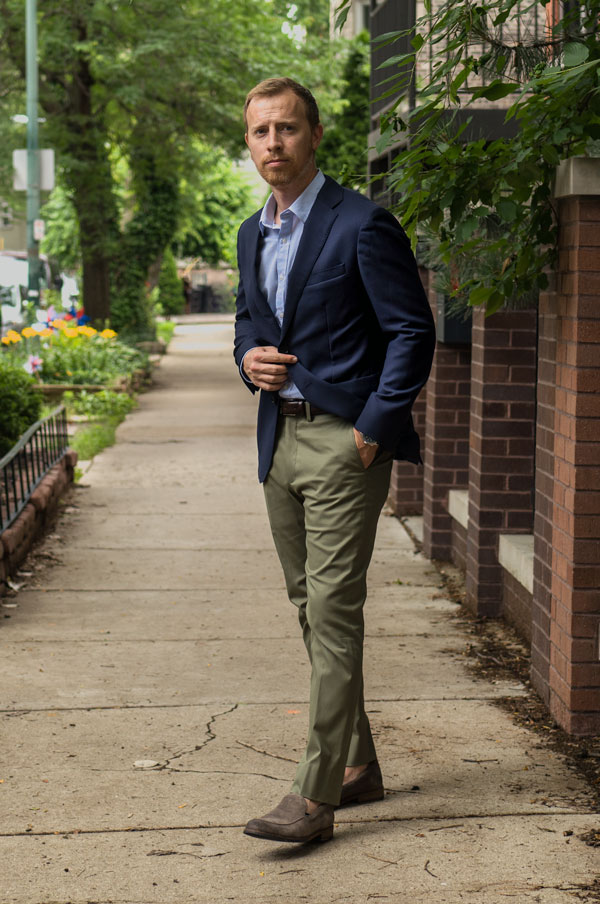 a man wearing a navy blazer over a shirt, pants, and loafers