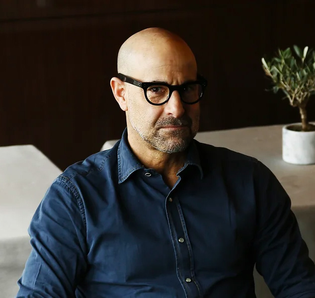 Stanley Tucci in glasses looking at the camera
