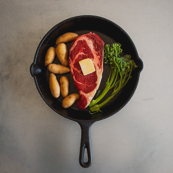 cast iron skillet with steak and vegetables