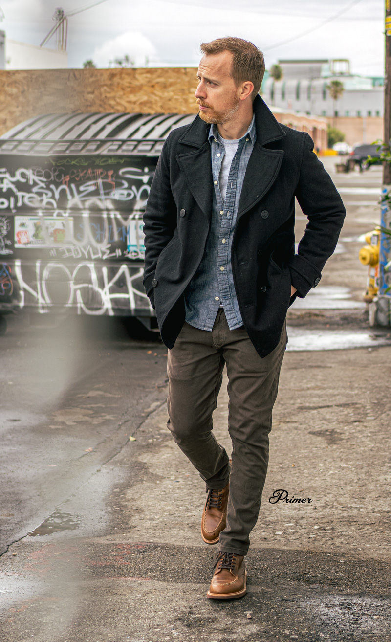 man wearing casual outfit idea rugged pea coat, chambray shirt, pocket tee, twill pants, moc toe boots