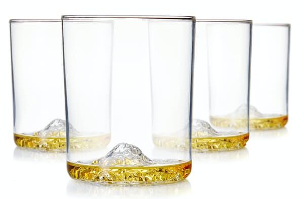 image of four whiskey glasses with mountain detail formation at the base of the glasses