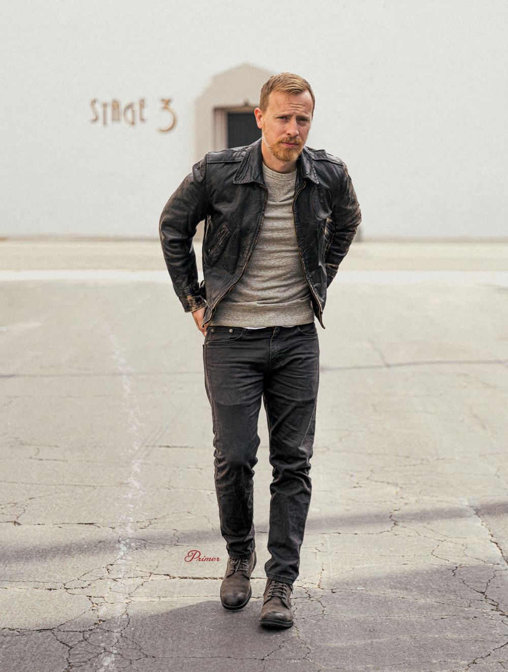 Andrew Snavely wearing black leather jacket, gray sweatshirt, charcoal jeans, gray boots monochrome outfit inspiration