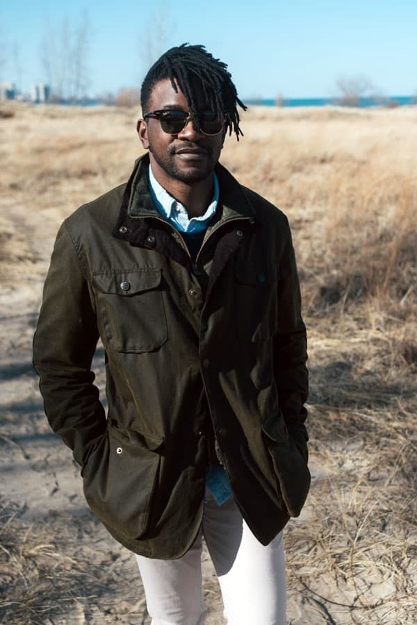 man wearing a waxed canvas jacket and white pants