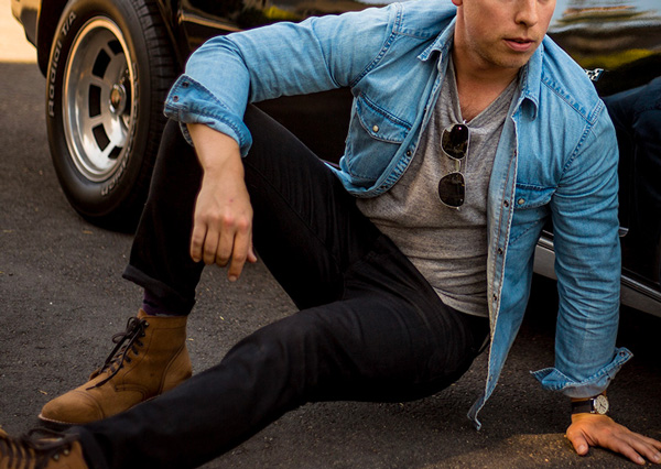 a man wearing a long sleeve chambray shirt over a shirt and black pants and brown shoes from Gap