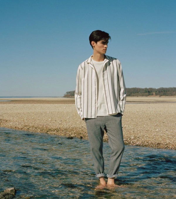 a man wearing a striped long sleeve shirt over a shirt and pants rolled at the ankles from Club Monaco