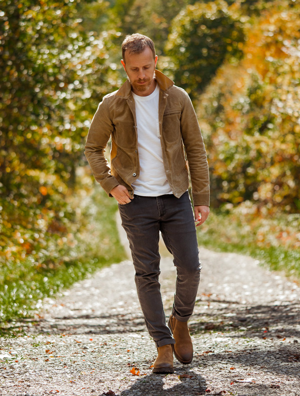 a man wearing a waxed canvas jacket from Rogue Territory with a shirt, pants, and boots