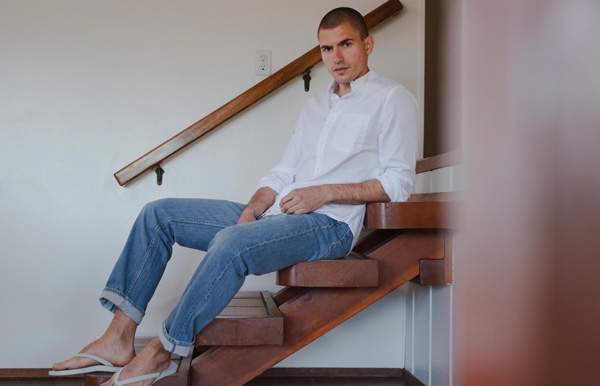 a man sitting on a flight of stairs wearing a button up shirt and jeans from Save Khaki