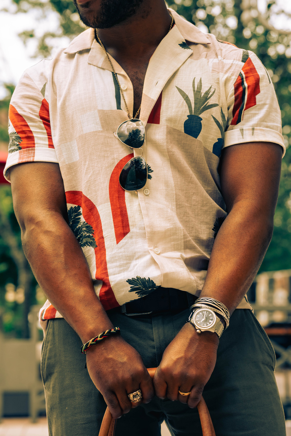 man wearing camp collar shirt with sunglasses, watch, and bracelet