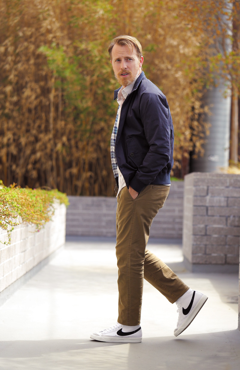 a man wearing a jacket with corduroy pants and leather nike high top shoes