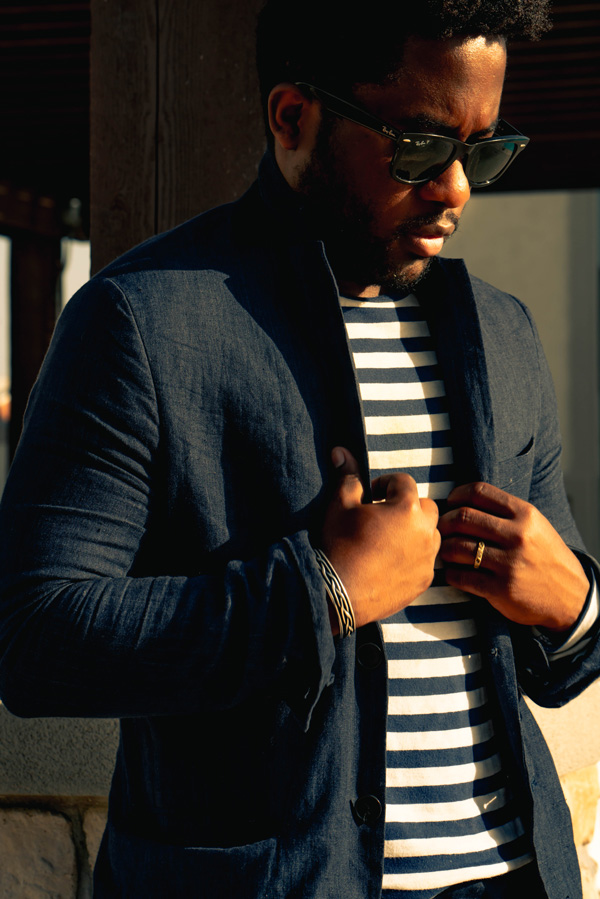 a man wearing a suit jacket over a striped shirt